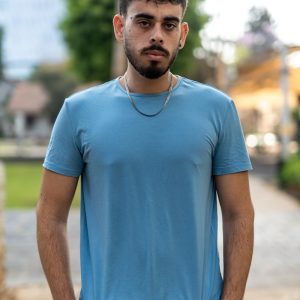 a man in a blue shirt standing on a sidewalk